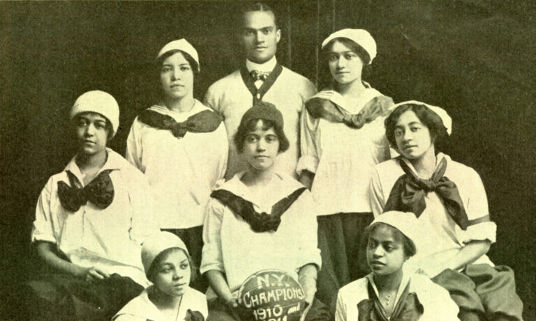 Black and white photo of seven Black women who were players on the New York Girls, all wearing white blouses with black skirts and a black bow around their necks,with one Black man who may have been their coach. One of the women is holding a basketball with the words “N.Y. Champions 1910” written on it.
