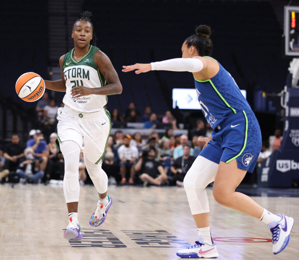 Jewell Loyd is mid-dribble with the ball while Kayla McBride of the Minnesota Lynx comes forward to guard her